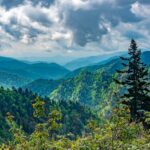 Lush green mountain peaks under a dramatic cloudy sky, highlighting outdoor family travel and kid-friendly attractions in the Great Smoky Mountains.